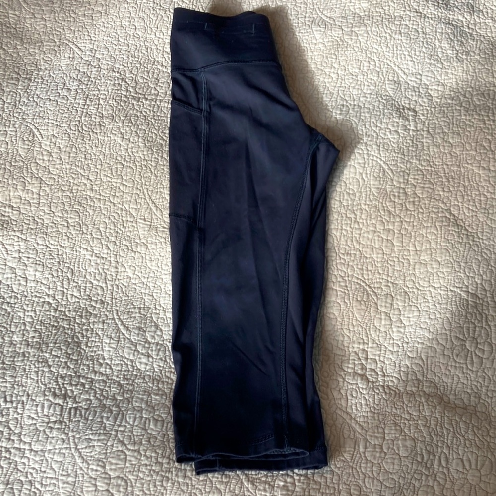 Lululemon size 8, black cropped leggings, cute scallop detail at back zipper.